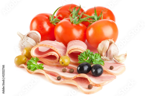 Tasty sliced bacon with vegetables and spices isolated on white