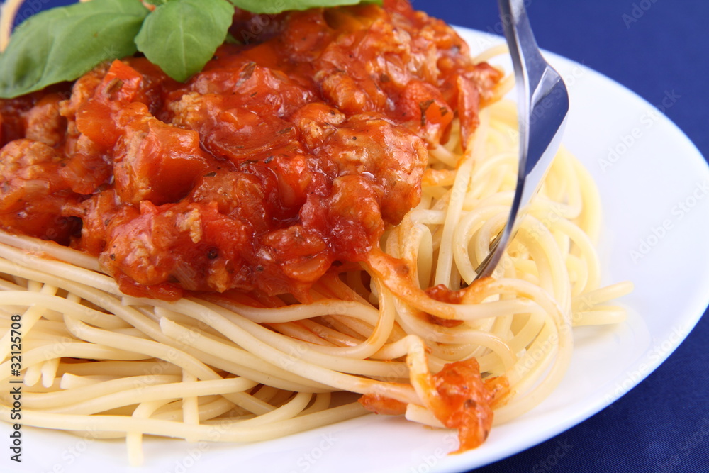 Spaghetti bolognese on a plate being eaten with a fork Spaghetti bolognese on a plate being eaten with a fork