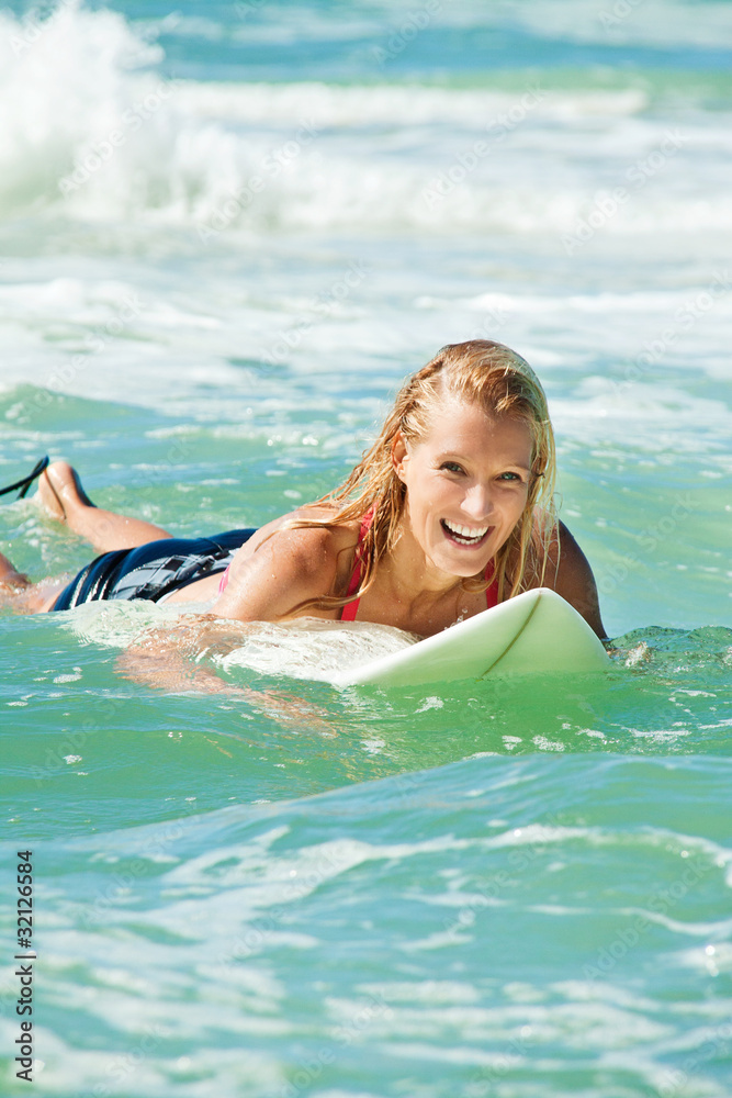 attractive woman bodyboards on surfboard