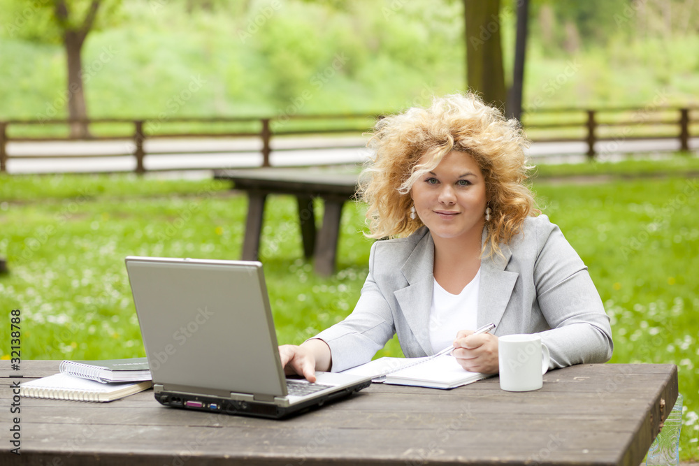 Woman using laptop in park Woman using laptop in park