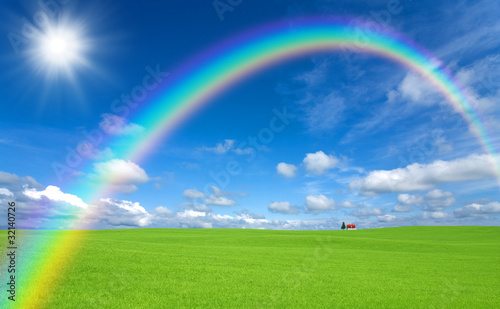 Green grass and red roof house and rainbow