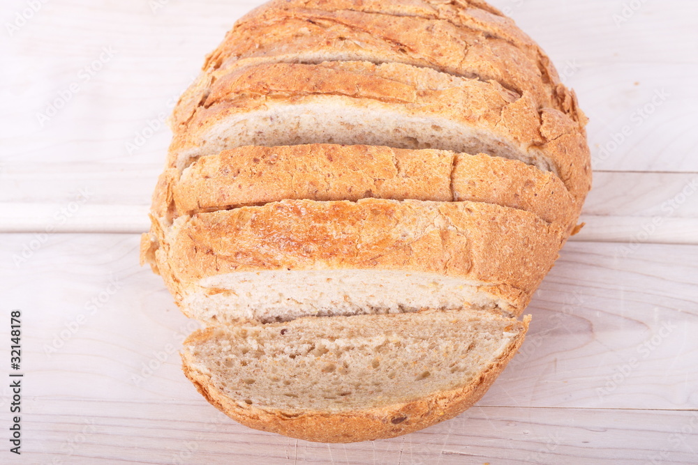 Sliced Loaf of Whole Wheat Bread on Wood Cutting Board Sliced Loaf of Whole Wheat Bread on Wood Cutting Board