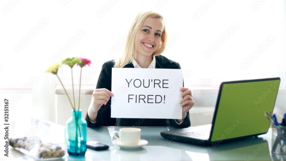 businesswoman showing paper sheet with YOU`RE FIRED sign
