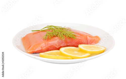 Fresh salmon steak with lemon slice and dill, isolated on white