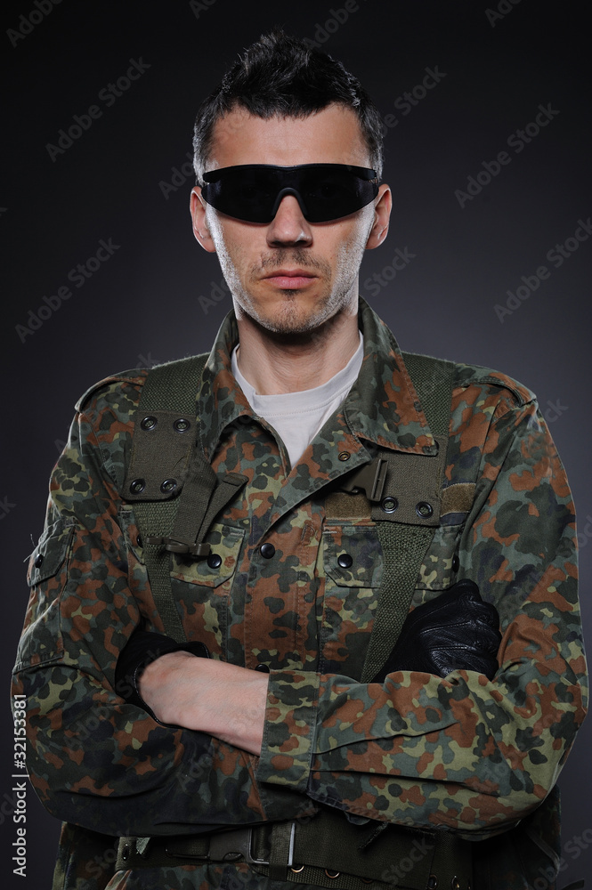 portrait of soldier in camouflage and ammunition . studio shot portrait of soldier in camouflage and ammunition . studio shot