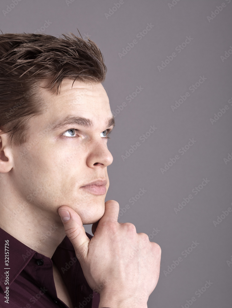 Junger Mann schaut nachdenklich nach oben Junger Mann schaut nachdenklich nach oben