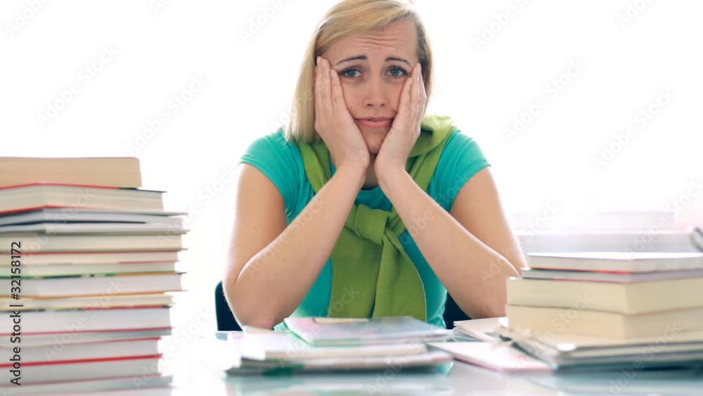 Worried unhappy female student with to much books Worried unhappy female student with to much books