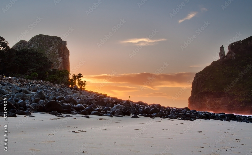 Sunrise landscape on the beach with rocks and cliffs clouds