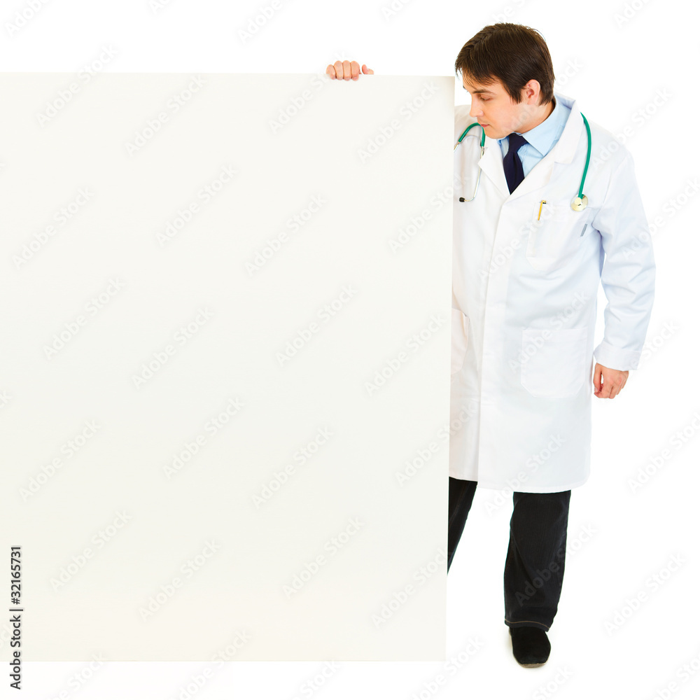 Full length portrait of doctor looking at blank billboard Full length portrait of doctor looking at blank billboard