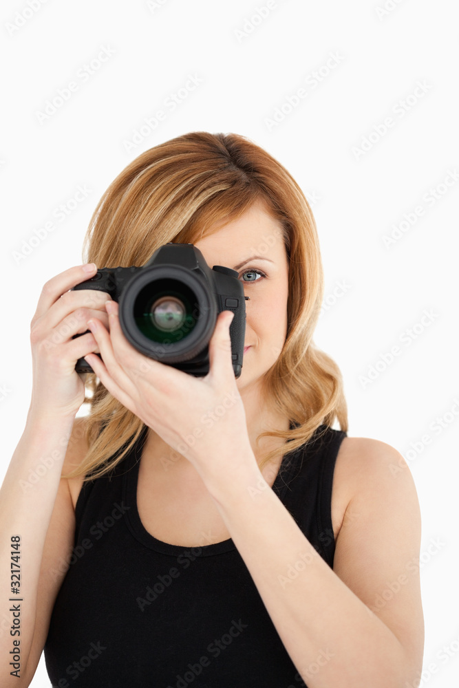 Attractive blond-haired woman taking a photo with a camera Attractive blond-haired woman taking a photo with a camera