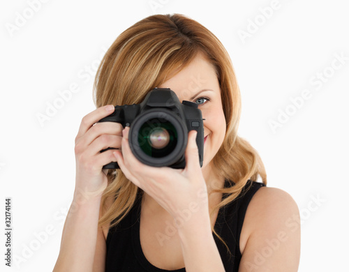 Blond-haired woman taking a photo with a camera