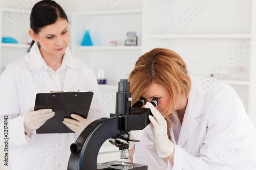 Blond-haired scientist and her assistant conducting an experimen