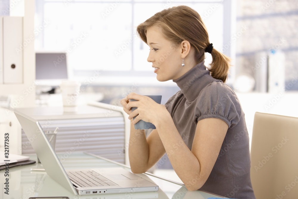 Attractive office worker drinking tea at desk Attractive office worker drinking tea at desk