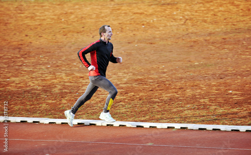 adult man running on athletics track