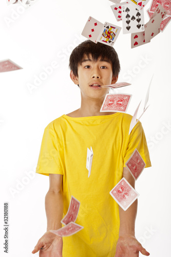teenage Chinese Asian boy playing with cards