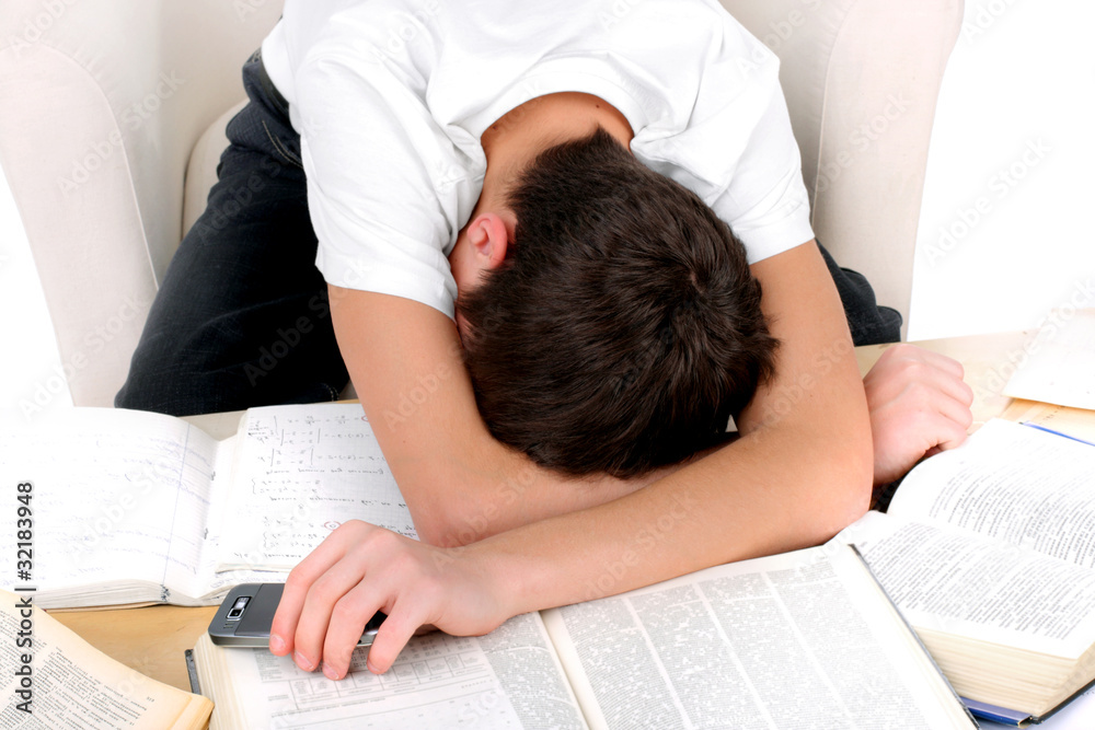 tired teenager lying and sleeping on the books