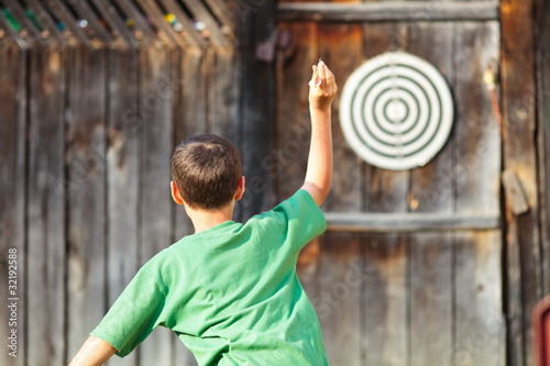 Boy playing darts outdoor photo