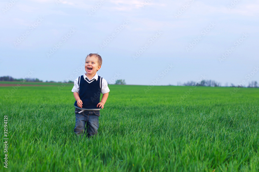 A beautiful little boy staing in the grass A beautiful little boy staing in the grass
