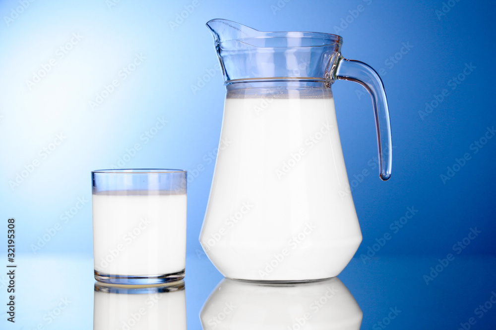 Pitcher and Glass with milk on blue background Pitcher and Glass with milk on blue background
