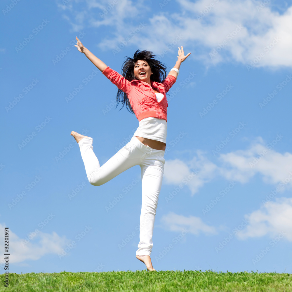 pretty young woman jumping on green grass pretty young woman jumping on green grass