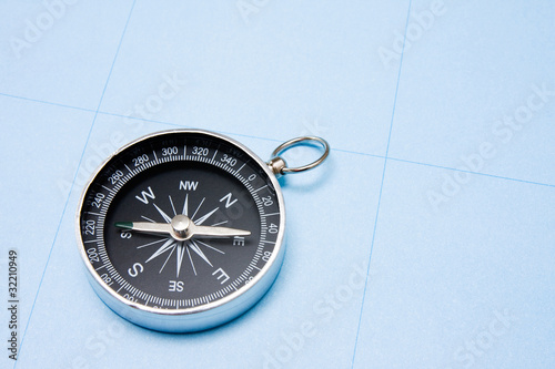 old black compass on blue paper background.