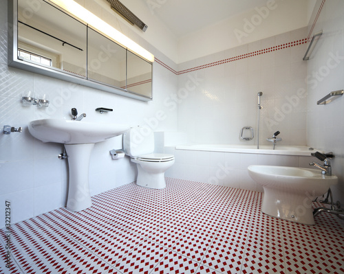 Nice modern bathroom. The tiles are red and white  none inside the room.