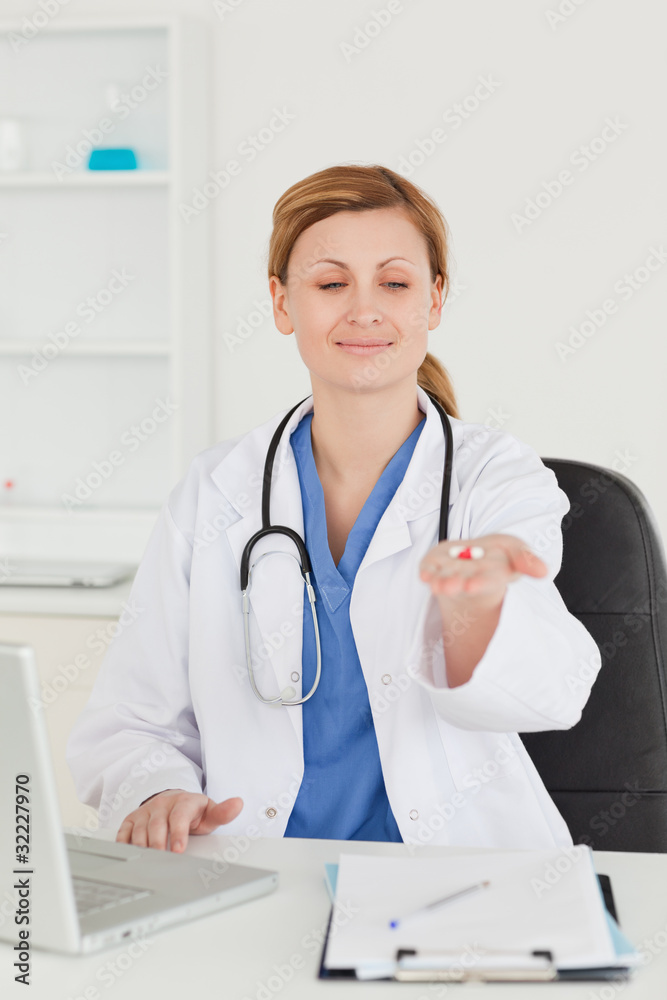 Attractive female doctor showing pills to the camera Attractive female doctor showing pills to the camera