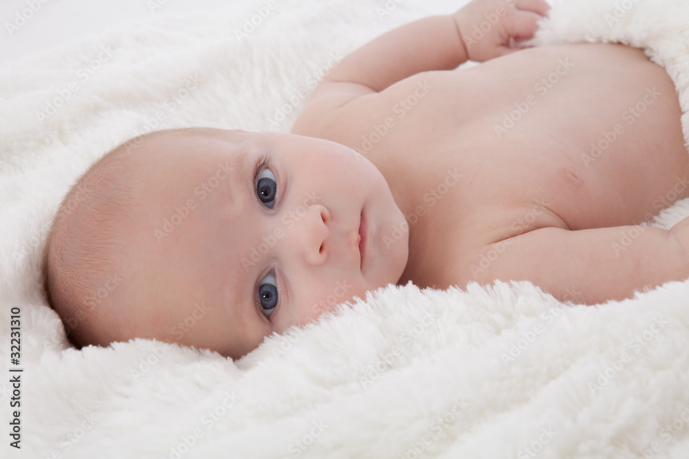 Adorable baby boy lying on fur blanket smiling Adorable baby boy lying on fur blanket smiling