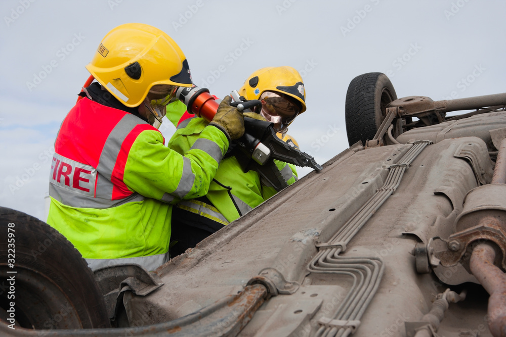 Fototapeta premium Firemen with Power Wedge at car crash