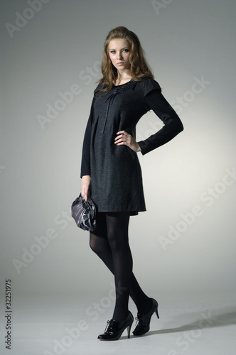 fashion model holding little purse in light background