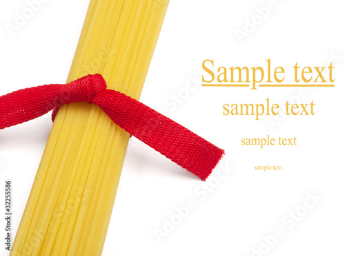 Bunch of spaghetti tied up with red ribbon isolated on white