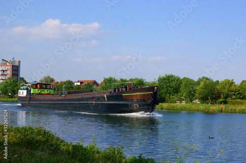River barge (rijnaak) on a small river in the netherlands Fotobehang