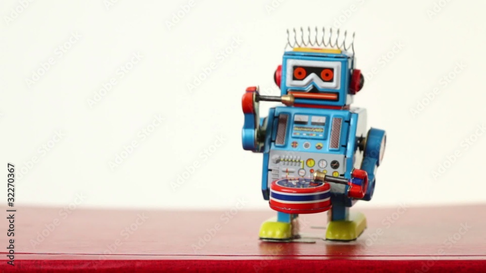 closeup of blue clockwork robot walks on table, beats drum