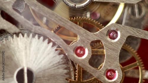 Moving metal gears inside working watch mechanism closer
