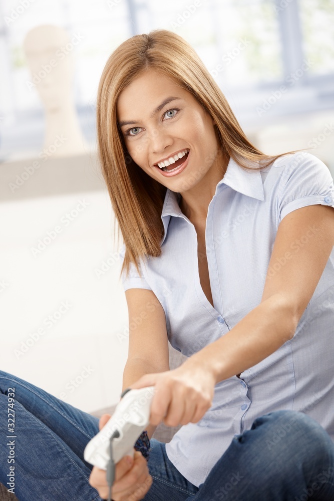 Young female playing video game smiling Young female playing video game smiling