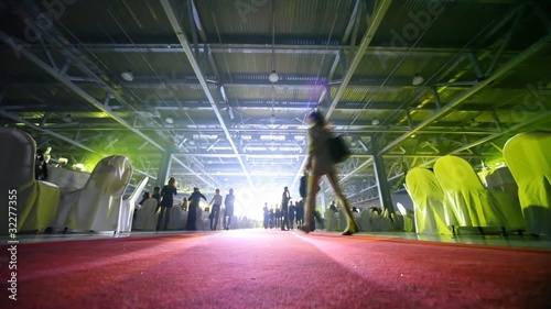 People are in hall which takes place banquet.