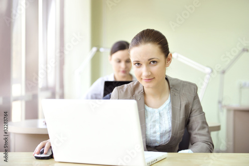 Portrait of two women working at their desks