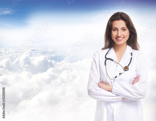 A young and attractive brunette female doctor in a white dress