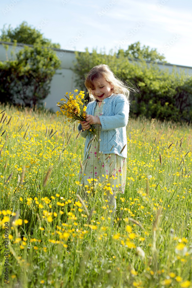 Fototapeta premium Mädchen pflückt einen Blumenstrauss für Mama