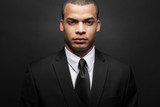 Young African-American businessman in black suit.