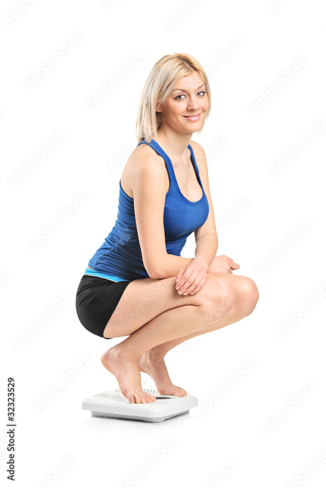 Obraz na plátně Smiling female on a weight scale