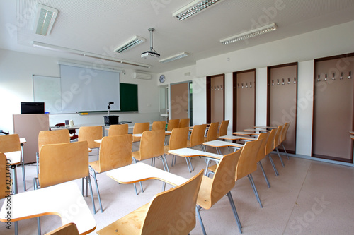 Traditional classroom with desk-chairs, chalkboard and projector