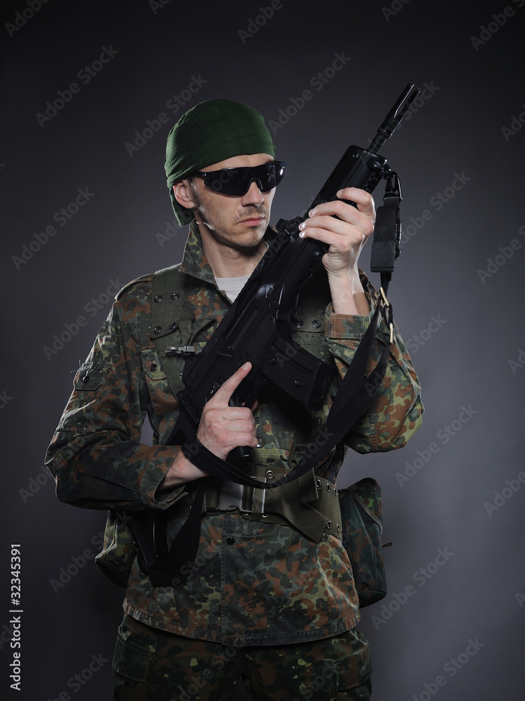 portrait of soldier in camouflage and ammunition with a rifle. s portrait of soldier in camouflage and ammunition with a rifle. s