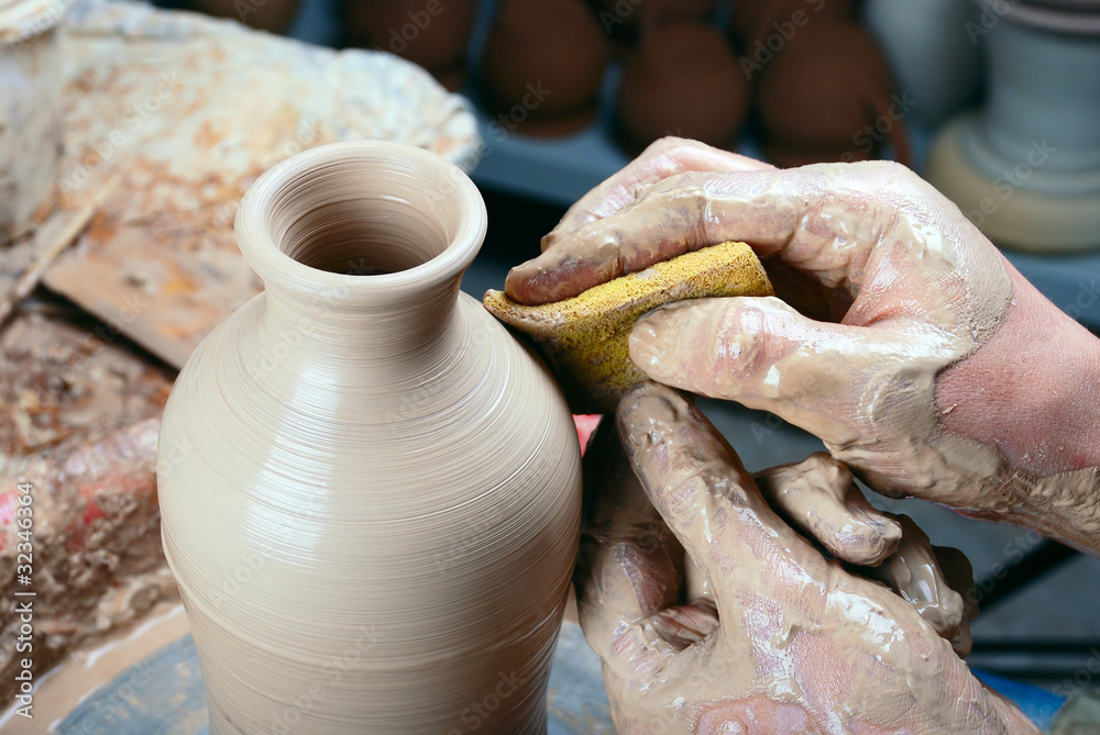 Ceramic bottle on a potter's wheel.Processing by a sponge