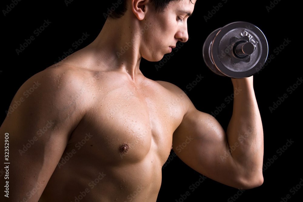 Muscular young man lifting dumbbells on black background. Muscular young man lifting dumbbells on black background.