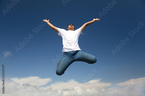 Happy man jumping with blue sky background