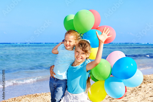 Children playing with balloons at the beach