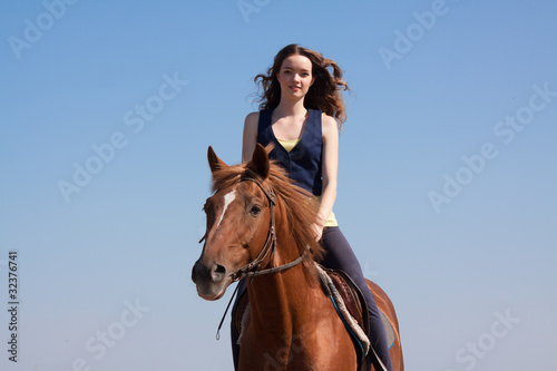 young cowgirl on brown horse