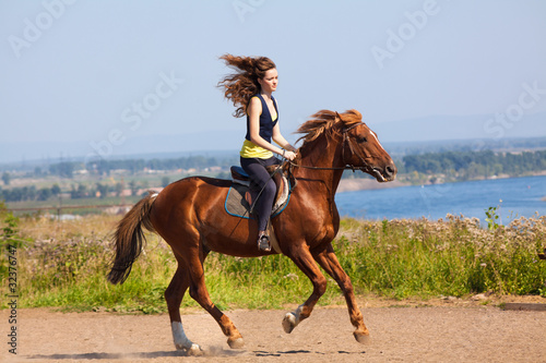 young cowgirl on brown horse
