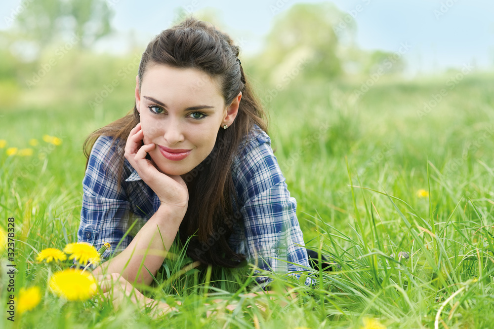 Portrait of beautiful young woman lying in grass Portrait of beautiful young woman lying in grass